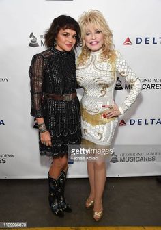 two women standing next to each other on a red carpet