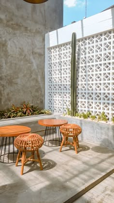 three wooden tables sitting on top of a cement floor