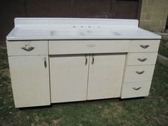 an old white kitchen sink sitting in the grass