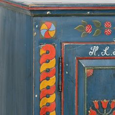 an old painted cabinet with flowers and leaves on the door is shown in this image