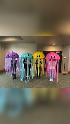 a group of people standing next to each other in front of jellyfish decorations on display