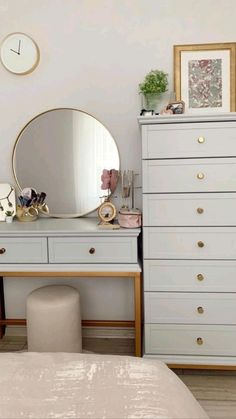 a bedroom with a dresser, mirror and stool