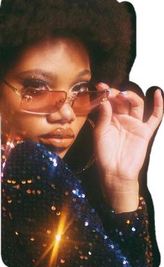 a woman wearing glasses and a sequin jacket talking on a cell phone while holding her hand up to her face