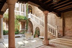 an outdoor courtyard with stone steps and columns