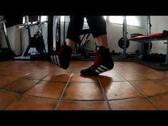 a person standing on top of a tile floor next to a gym equipment set up