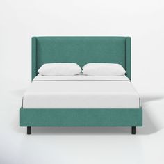 a bed with white pillows and green headboard