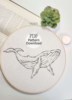 a cross stitch pattern with a whale on it and a candle in front of it