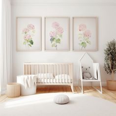 a baby's room with pink flowers on the wall and a white crib