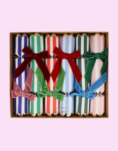 six different colored bow ties in a box