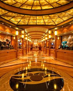 the inside of a large building with gold and black decorations on the ceiling, along with marble flooring