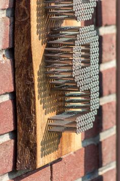 a close up of a wooden comb on a brick wall