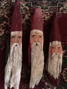 three gnomes made out of wood sitting on top of a rug