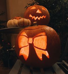 two carved pumpkins sitting on top of a table