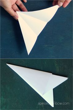 someone is making an origami airplane out of paper and then fold it in half