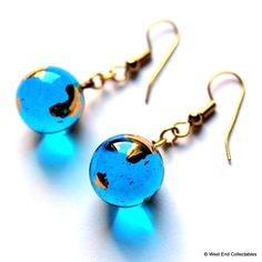 A stunning pair of earrings made with a mounted pair of miniature gold Earth Marbles. The suspended Earth Globes measure 12mm (0.5") diameter and; with geographic accuracy, depict the continents of the world in bright 22ct Gold. High quality Marbles are finished in coloured glass, in direct light they shine a most beautiful crystal blue. An exceptionally attractive set, an ideal gift for someone special. Telescope Astronomy, Continents Of The World, Marble Earrings, Earth Globe, Coloured Glass, Globe Pendant, Glass Marbles, Fun Earrings, Planet Earth