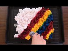 someone is using a cloth to make a rainbow cake