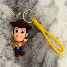 a toy keychain with a cartoon character on it sitting on a furry surface