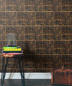 a table with a suitcase and some books on it next to a wall that has a pattern