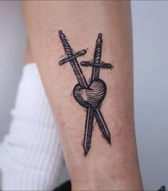 a tattoo on the arm of a woman with two swords and a heart in it