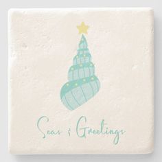 a square coaster with a blue christmas tree on it and the words seat greetings written below