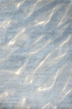 an area rug that is made up of blue and white colors with water ripples on it