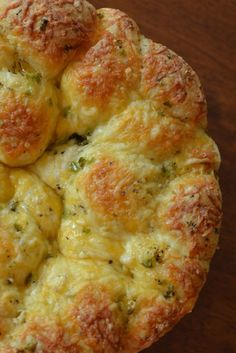 a cheesy bread with broccoli and cheese in it on a wooden table