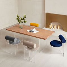 a dining room table with chairs and a vase filled with flowers on top of it