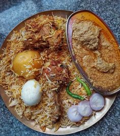 a plate with rice, meat and eggs on it next to some other food items