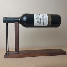 a bottle of wine sitting on top of a wooden stand