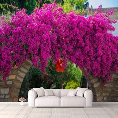 a white couch sitting under a purple flower covered tree