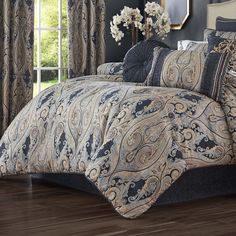 the comforter is made up with black and gold paisley designs on it, along with matching pillows