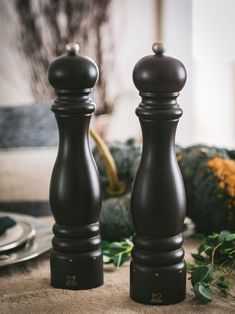 two black salt and pepper shakers sitting on top of a table