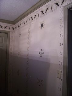 the wall is painted with white paint and has black birds on it's border