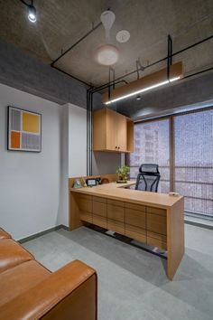 an office with a desk, chair and window in the middle of it's room