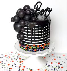 a black and white cake with grapes on top