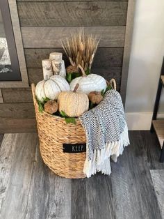 a basket filled with white pumpkins on top of a wooden floor