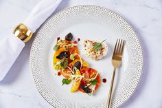 a white plate topped with food next to a fork and knife on top of a table