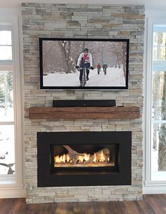 a flat screen tv mounted above a fire place