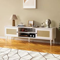 a living room with a white entertainment center and wooden floors in front of a beige wall