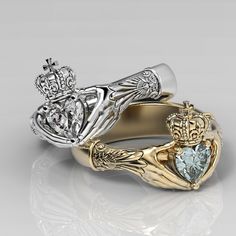 two gold and silver wedding rings with an aqua topazte stone in the center