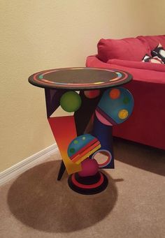 a small table that is on the floor in front of a red chair and couch