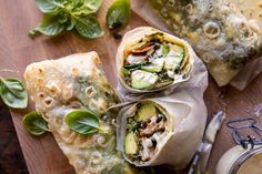 some food is wrapped in paper and sitting on a cutting board with utensils