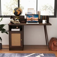 a laptop computer sitting on top of a wooden desk next to a potted plant