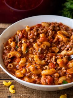 a white bowl filled with pasta and meat