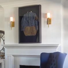 a blue chair sitting in front of a fire place next to a painting on the wall