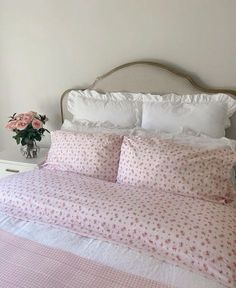 a bed with pink flowers and white sheets