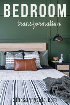 a bed room with a neatly made bed next to a green wall and wooden headboard