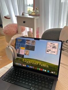 an open laptop computer sitting on top of a wooden table in front of a window