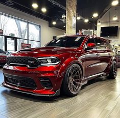 a red dodge charger parked in a showroom