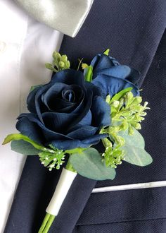 a boutonniere with blue flowers and greenery